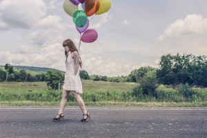 mujer-con-globos-sobre-carretera-triste-300x200